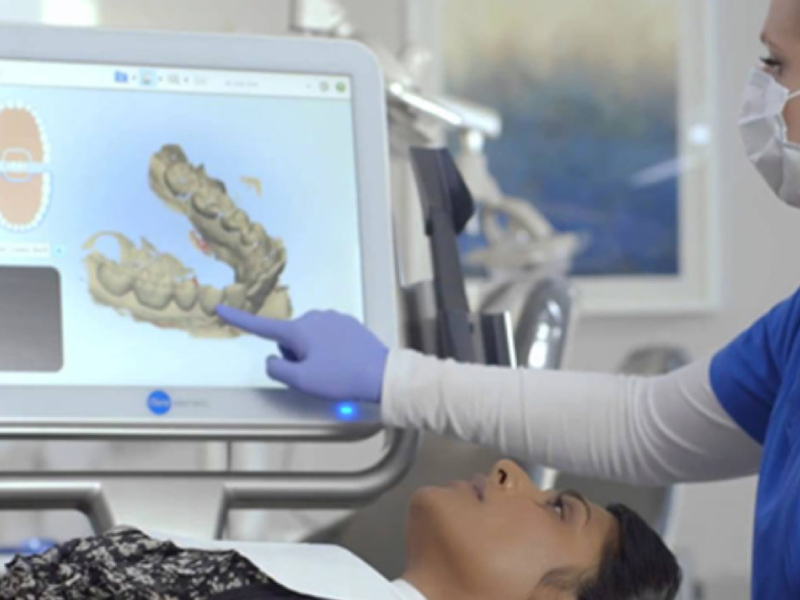 A dentist examining a patient with the help of new dental technology.