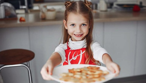 A smiling girl with a plate of snacks depicting entrepreneurial ideas among kids